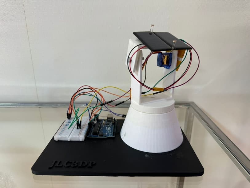 Front view of the assembled Solar Tracker showing its Arduino, breadboard, wiring, servo, sensors, panel, and printed frame